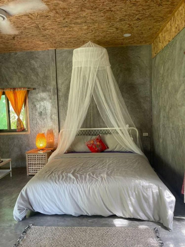Bedroom with polished concrete walls and a round mosquito net